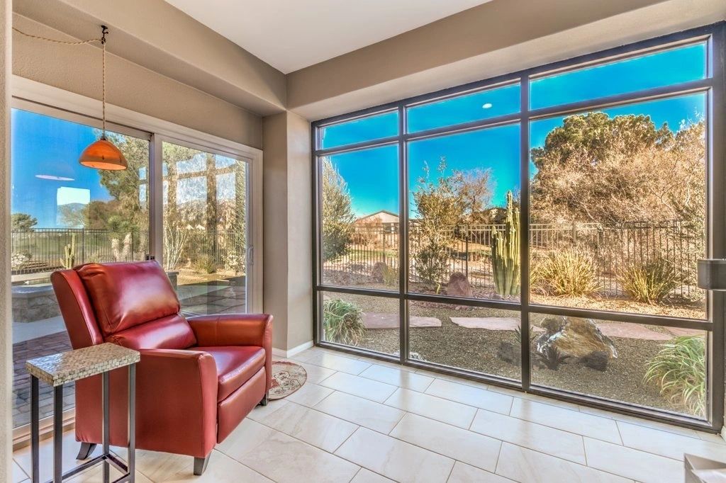 Red chair beside large windows overlooking a garden
